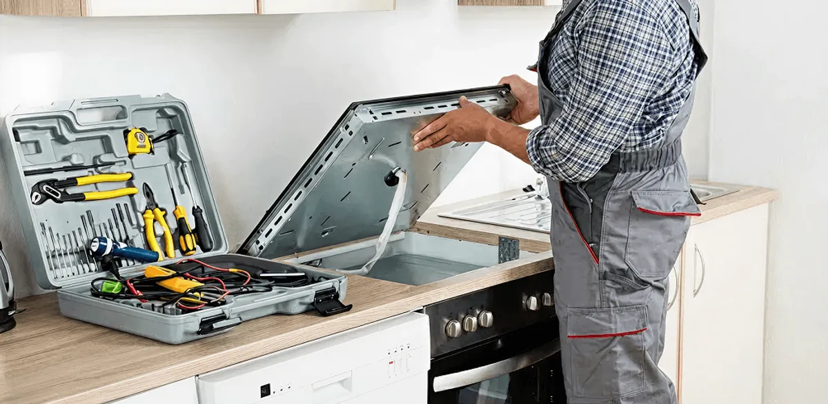Handyman repairing a cooktop and checking wiring connections in Dover, DE