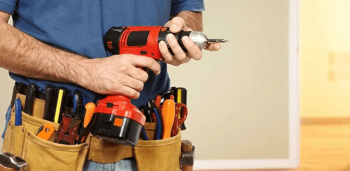 Handyman holding a power drill for home repairs and installations in Dover, DE